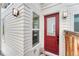 Inviting front entrance with a vibrant red door and modern lighting fixtures at 6366 N Emporia St, Denver, CO 80238