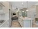 Bright kitchen with stainless steel appliances, white cabinetry, quartz countertops, and island overlooking the living spaces at 6366 N Emporia St, Denver, CO 80238