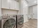 Well-equipped laundry room with modern appliances, storage cabinets, and a clean design, making laundry tasks efficient at 6366 N Emporia St, Denver, CO 80238