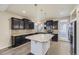 Stylish kitchen featuring dark cabinets, granite counters, stainless steel appliances, and an island with pendant lighting at 2564 Sweet Wind Ave, Castle Rock, CO 80109