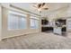 Spacious living room featuring a large window, neutral carpet, ceiling fan, and seamless flow into the kitchen at 2564 Sweet Wind Ave, Castle Rock, CO 80109