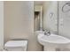Neat powder room features pedestal sink, decorative mirror, and tiled walls at 2564 Sweet Wind Ave, Castle Rock, CO 80109