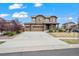 Charming two-story home with brick accents, a well-manicured lawn, and a spacious three car driveway at 224 S Jackson Gap Way, Aurora, CO 80018
