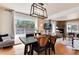 Bright dining room with modern light fixture, wooden table, and view of stone fireplace at 6192 S Pennsylvania St, Centennial, CO 80121