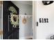 Cozy entryway with black door, leafy wreath, number 6192, and coat rack at 6192 S Pennsylvania St, Centennial, CO 80121