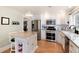 Kitchen featuring white cabinetry, butcher block island, stainless appliances, and hardwood floors at 6192 S Pennsylvania St, Centennial, CO 80121