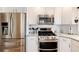 Kitchen features stainless steel appliances, white cabinets, and modern fixtures at 6192 S Pennsylvania St, Centennial, CO 80121