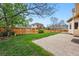 Landscaped backyard featuring a lawn, wood fence, and a brick patio at 9515 Dolton Way, Highlands Ranch, CO 80126