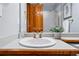 Updated bathroom featuring a white sink, wood cabinet, gold fixtures, and shower with glass doors at 9515 Dolton Way, Highlands Ranch, CO 80126