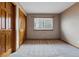 This cozy bedroom features neutral carpet, a window with blinds, and paneled closet doors at 9515 Dolton Way, Highlands Ranch, CO 80126