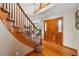 Inviting foyer with wood floors, paneled front door, and staircase with carpet runner at 9515 Dolton Way, Highlands Ranch, CO 80126
