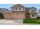 Inviting two-story home with a three-car garage, manicured lawn, and charming architectural details at 9515 Dolton Way, Highlands Ranch, CO 80126