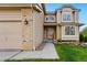Beautiful home exterior showcasing the entry with manicured lawn, and a three-car garage at 9515 Dolton Way, Highlands Ranch, CO 80126