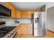 Modern kitchen featuring stainless steel appliances, light wood cabinets, and a gas range stove at 9515 Dolton Way, Highlands Ranch, CO 80126