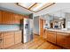 Open kitchen with stainless steel appliances, wood cabinets, and connection to the main living space at 9515 Dolton Way, Highlands Ranch, CO 80126