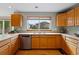 Well-lit kitchen showcasing wood cabinets, dual sinks, and a large window overlooking the backyard at 9515 Dolton Way, Highlands Ranch, CO 80126
