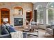 Comfortable living room showcasing a cozy brick fireplace, built-in shelving, and views from large windows at 9515 Dolton Way, Highlands Ranch, CO 80126