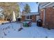 Patio area in snowy backyard with table and chairs, perfect for outdoor dining at 5221 W Rowland Pl, Littleton, CO 80128