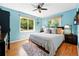 Comfortable bedroom with two windows, hardwood floors, a ceiling fan, and an area rug at 1332 Ash St, Denver, CO 80220