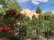 Charming home with lush landscaping featuring vibrant red roses and a decorative black metal fence at 1332 Ash St, Denver, CO 80220