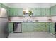 Bright kitchen with ample counter space, stainless steel appliances, and classic mint green cabinetry at 1332 Ash St, Denver, CO 80220
