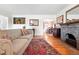 Cozy living room with a decorative fireplace, a colorful rug, and bright hardwood floors at 1332 Ash St, Denver, CO 80220
