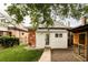Charming backyard featuring white outbuilding, brick facade and lush green lawn at 4430 Zuni St, Denver, CO 80211