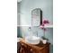Stylish bathroom featuring a vessel sink on a vintage dresser and a round mirror at 4430 Zuni St, Denver, CO 80211
