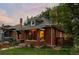 Charming brick home featuring front porch, manicured lawn and mature trees at 4430 Zuni St, Denver, CO 80211