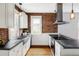 Bright kitchen with stainless appliances, exposed brick, and hardwood floors at 4430 Zuni St, Denver, CO 80211
