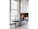 Close-up of the kitchen sink area with exposed brick and bright light from the windows at 4430 Zuni St, Denver, CO 80211