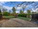 Private backyard featuring a gravel patio area and green spaces surrounded by mature trees and lush landscaping at 482 W Caley Ave, Littleton, CO 80120