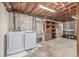 Utility area with washer, dryer, utility sink, exposed beams and wood shelving at 482 W Caley Ave, Littleton, CO 80120