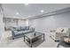 Basement living area with a modern couch, patterned arm chair and a table at 482 W Caley Ave, Littleton, CO 80120