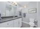 Bright bathroom features a modern vanity with gray countertop and framed plant art at 482 W Caley Ave, Littleton, CO 80120