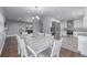 Open concept dining area with large white table, chandelier, and views into the living room and kitchen at 482 W Caley Ave, Littleton, CO 80120