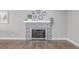Stylish fireplace with decorative tile surround, elegant mantel, and complemented by hardwood floors at 482 W Caley Ave, Littleton, CO 80120