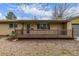 Inviting front porch with a charming railing, leading to the entrance of this beautifully maintained home at 482 W Caley Ave, Littleton, CO 80120