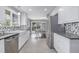Modern kitchen with white cabinets, stainless steel appliances, and an open layout to the dining area at 482 W Caley Ave, Littleton, CO 80120