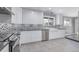 Bright kitchen with white cabinetry, stainless steel appliances, and a farmhouse sink beneath a window at 482 W Caley Ave, Littleton, CO 80120