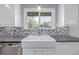 Bright kitchen featuring a white farmhouse sink, modern faucet, and tiled backsplash under a window at 482 W Caley Ave, Littleton, CO 80120