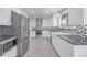 Modern kitchen features white cabinets, stainless steel appliances, and gray diamond patterned backsplash at 482 W Caley Ave, Littleton, CO 80120