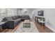 Modern living room featuring hardwood floors, a comfortable sofa, and a stylish rug for a cozy and inviting atmosphere at 482 W Caley Ave, Littleton, CO 80120