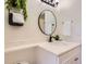 Close up of modern bathroom featuring marble countertops and a round mirror at 10239 W Fair Ave # A, Littleton, CO 80127