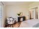 Bright bedroom features a comfortable chair and table by a sliding glass door that lets in natural light and offers nice views at 10239 W Fair Ave # A, Littleton, CO 80127