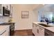 Beautifully designed kitchen featuring white cabinetry, stainless steel appliances, and stylish backsplash with modern fixtures at 10239 W Fair Ave # A, Littleton, CO 80127