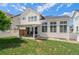Back exterior of home featuring a patio with furniture and a spacious yard with fresh green grass at 4670 Tanner Peak Trl, Brighton, CO 80601