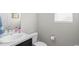 Half bathroom with a white sink, toilet, and a small window providing natural light at 4670 Tanner Peak Trl, Brighton, CO 80601