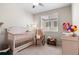 Cozy Bedroom with a white crib, rocking chair, changing table, and a window with natural light at 4670 Tanner Peak Trl, Brighton, CO 80601