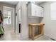 Hallway with wood-look flooring, white walls, a table, and cabinets for storage at 4670 Tanner Peak Trl, Brighton, CO 80601